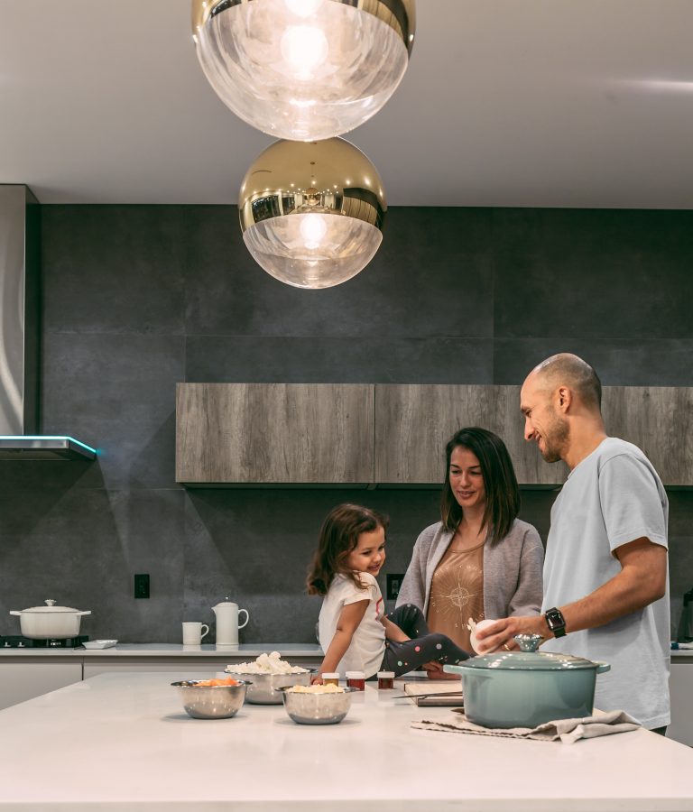 Conciliación familiar: familia preparando la comida juntos en una cocina moderna.