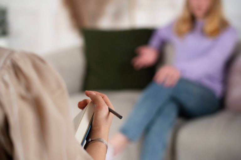 Terapeuta tomando notas durante una sesión con una paciente.